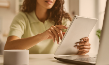 Mulher utilizando um tablet em ambiente de trabalho, representando o uso consciente e seguro da tecnologia.